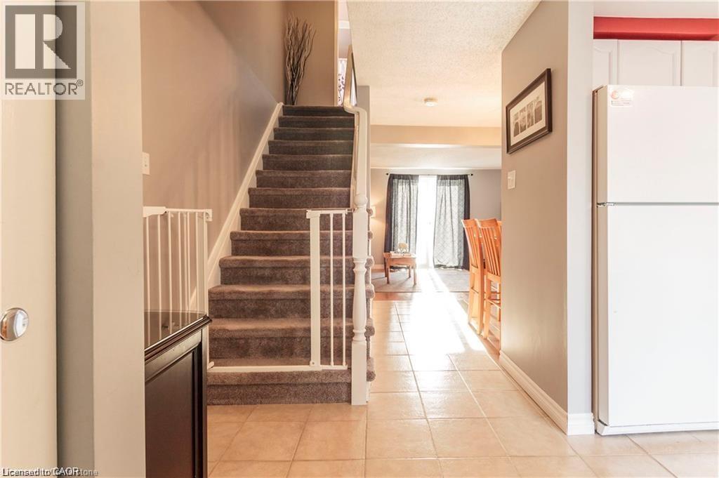 Carpeted staircase with white railings - 209 Auburn Drive Unit# A, Waterloo, ON