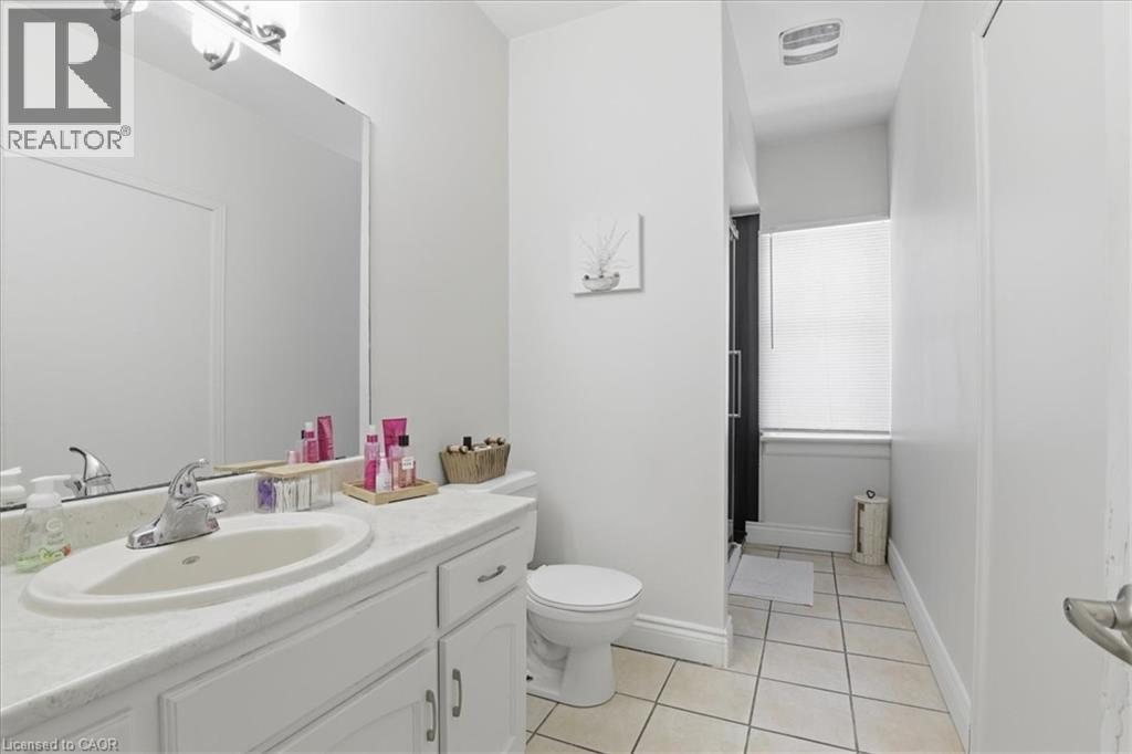Bathroom featuring a single vanity with an integrated sink, polished chrome faucet, and white cabinetry - 744 Queen Street S, Kitchener, ON