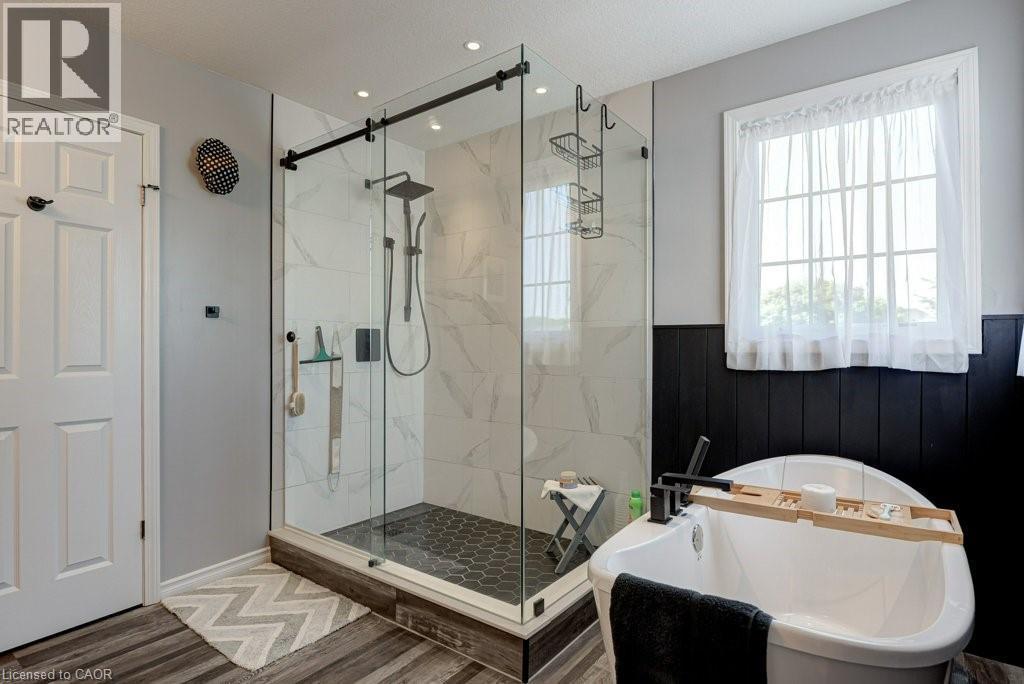 Glass-enclosed shower with subway tile surround, hexagon tile flooring, and a matte black rainfall showerhead - 61 Ditner Avenue, Baden, ON - Indoor Photo Showing Bathroom