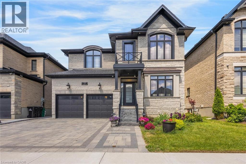 Stone-clad exterior featuring a two-car garage with black doors - 57 Hollybrook Trail, Kitchener, ON