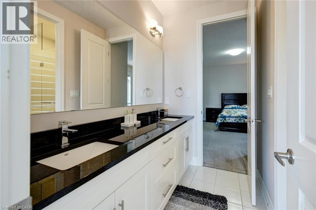 Dual vanity with dark countertop, undermount sinks, and chrome fixtures - 57 Hollybrook Trail, Kitchener, ON