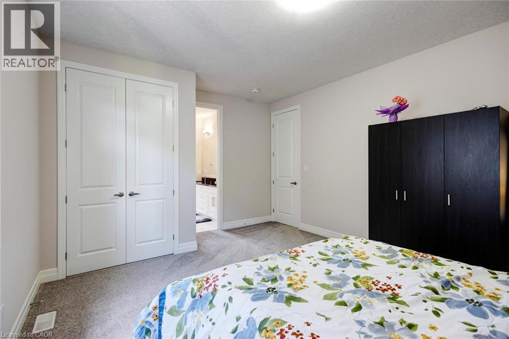 Plush grey carpeting and neutral wall paint define this interior space - 57 Hollybrook Trail, Kitchener, ON