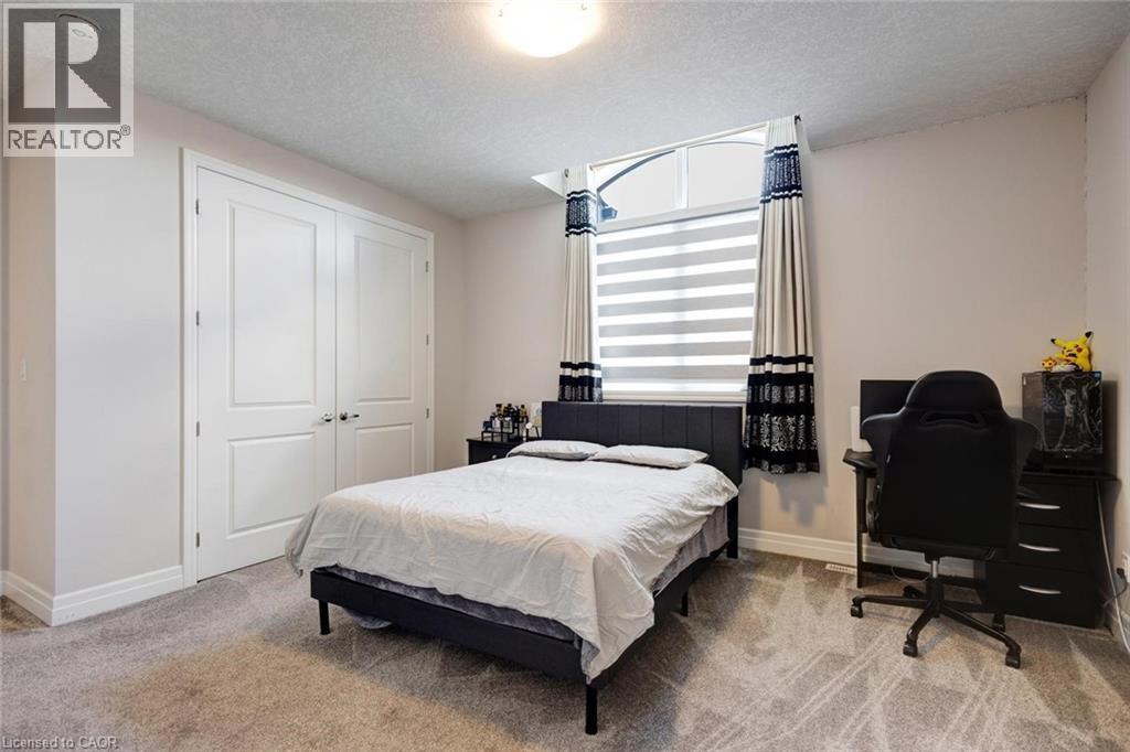 Room featuring light gray walls, textured carpet flooring, and a flush-mount ceiling light - 57 Hollybrook Trail, Kitchener, ON