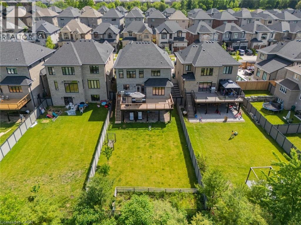Expansive backyard featuring a manicured lawn, a raised wooden deck with stairs to grade, and a privacy fence - 57 Hollybrook Trail, Kitchener, ON