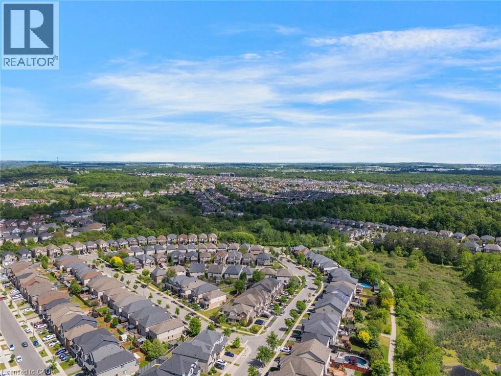 Aerial perspective showcasing a residential community surrounded by expansive natural green spaces - 57 Hollybrook Trail, Kitchener, ON