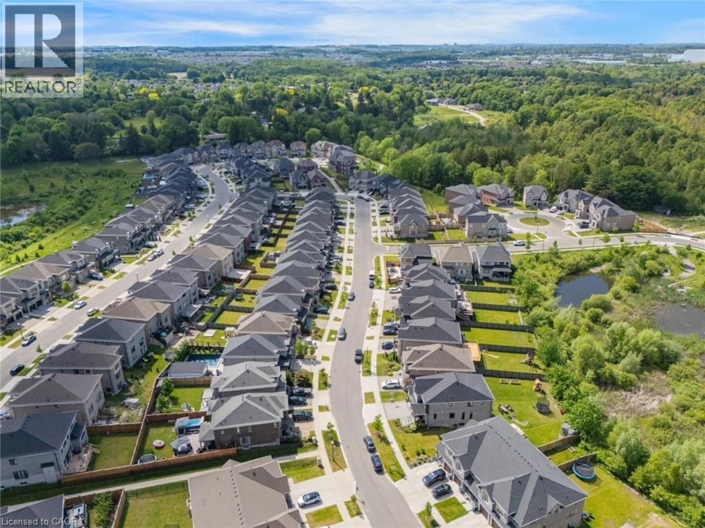 Aerial perspective of a developed residential area featuring rows of detached homes with varied architectural styles and gray pitched roofs - 57 Hollybrook Trail, Kitchener, ON