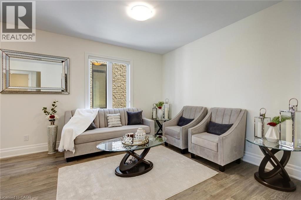Bright living space featuring wood-finish flooring and a neutral color palette - 57 Hollybrook Trail, Kitchener, ON