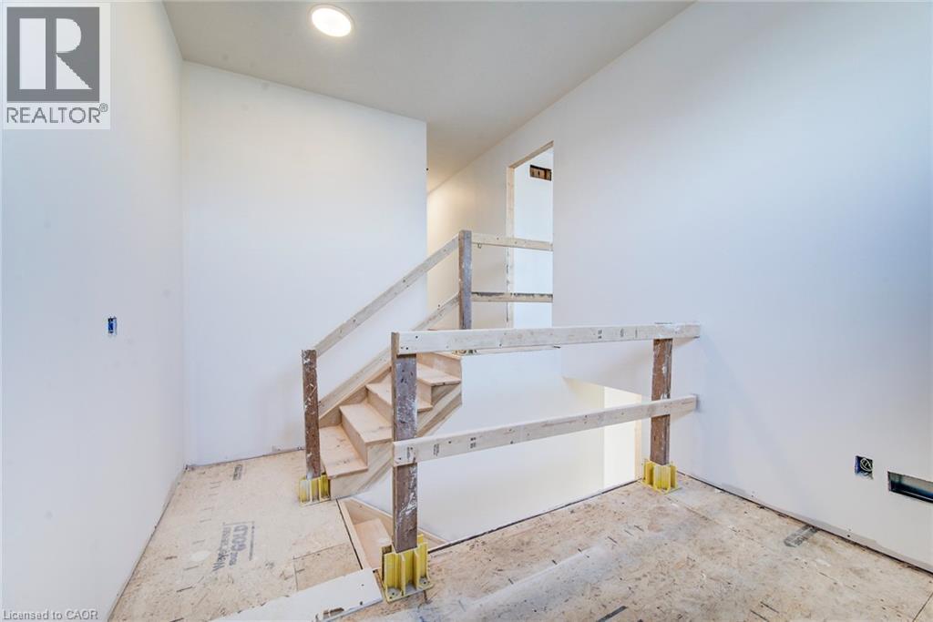 Unfinished interior staircase featuring exposed wood treads and temporary railing - 114 Bedell Drive, Mapleton, ON - Indoor Photo Showing Other Room