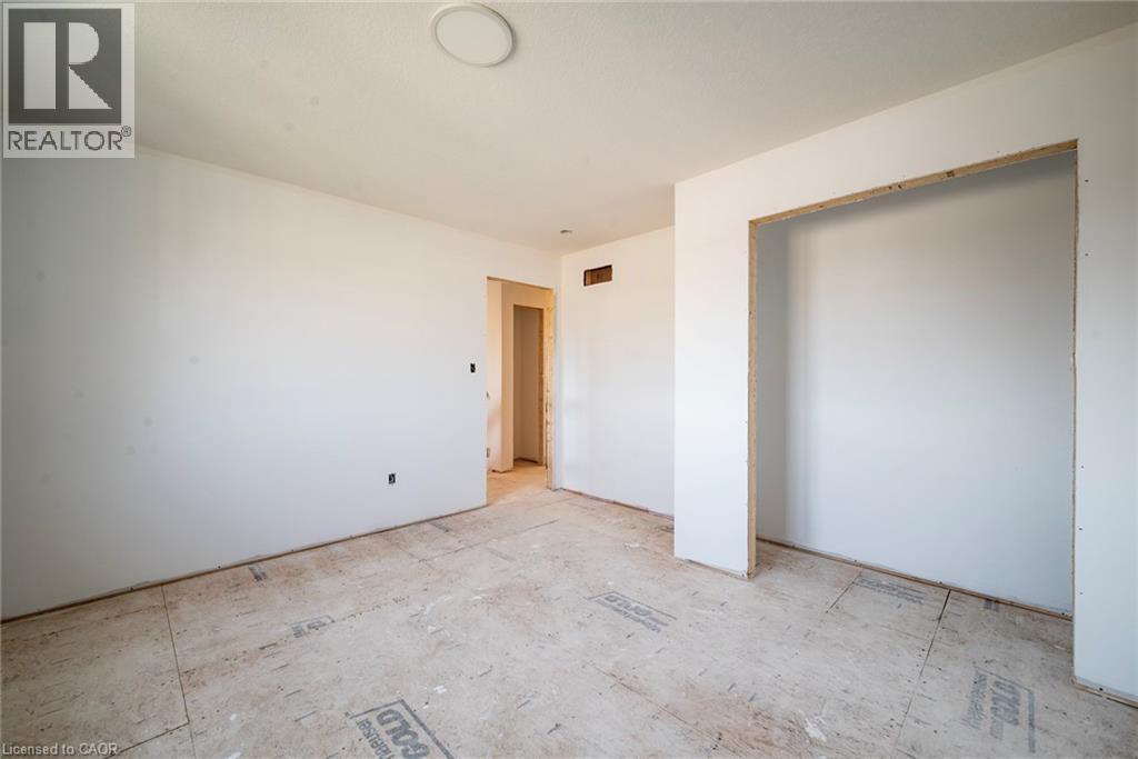 Spacious interior room featuring white painted walls and subflooring, offering an open concept for customization - 114 Bedell Drive, Mapleton, ON - Indoor Photo Showing Other Room