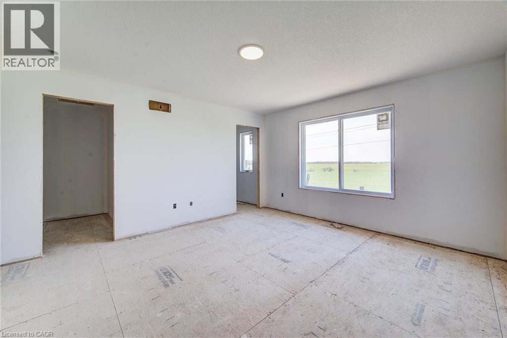Spacious room featuring a large window, recessed lighting, white walls, and a new subfloor - 114 Bedell Drive, Mapleton, ON - Indoor Photo Showing Other Room