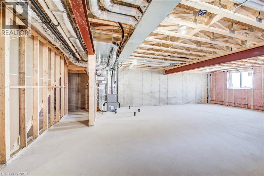 Unfinished basement featuring exposed wood framing, concrete flooring, and visible HVAC ductwork - 114 Bedell Drive, Mapleton, ON - Indoor Photo Showing Basement