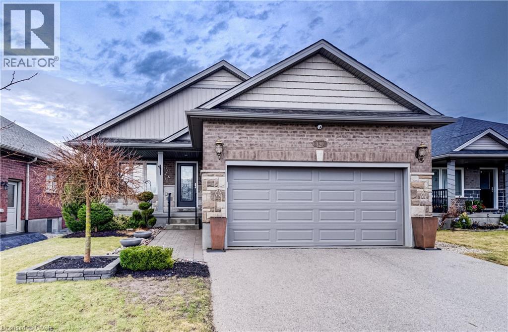 Ranch-style house featuring brick siding, driveway, a garage, and a front yard - 130 Bridge Crescent, Minto, ON