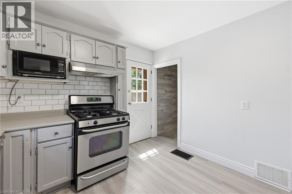 Kitchen featuring light gray cabinetry with brushed nickel hardware, a stainless steel gas range - 97 Tragina Avenue S, Hamilton, ON