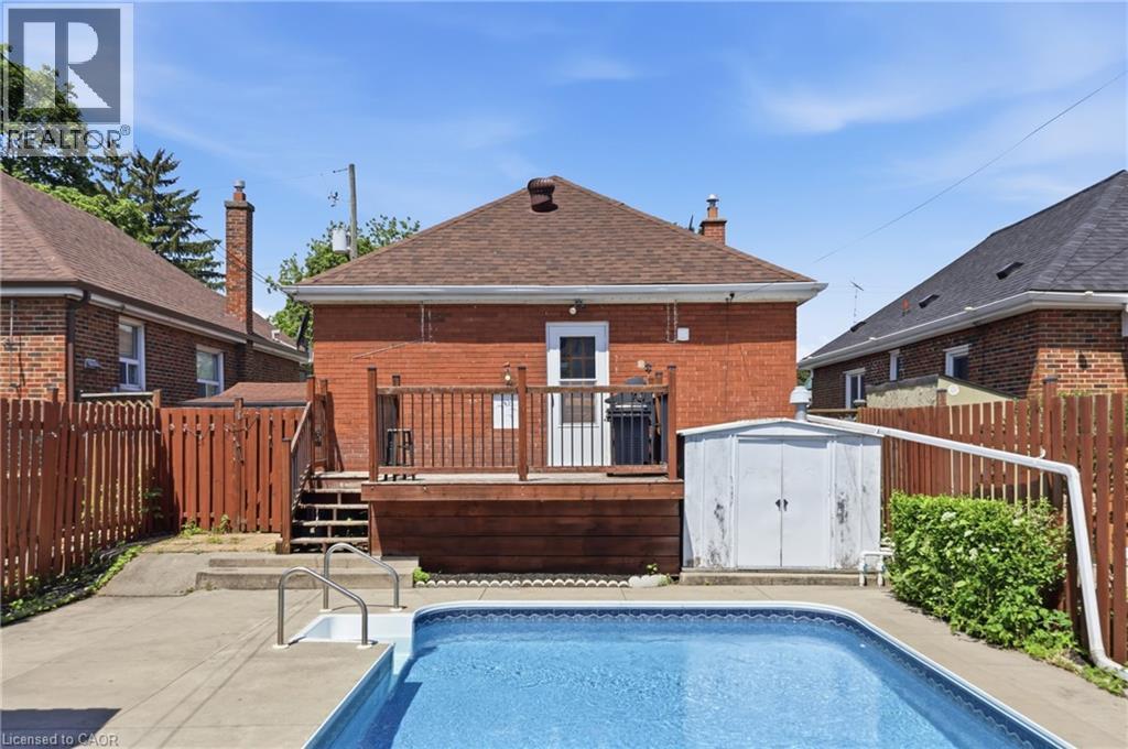 In-ground swimming pool with surrounding concrete patio - 97 Tragina Avenue S, Hamilton, ON