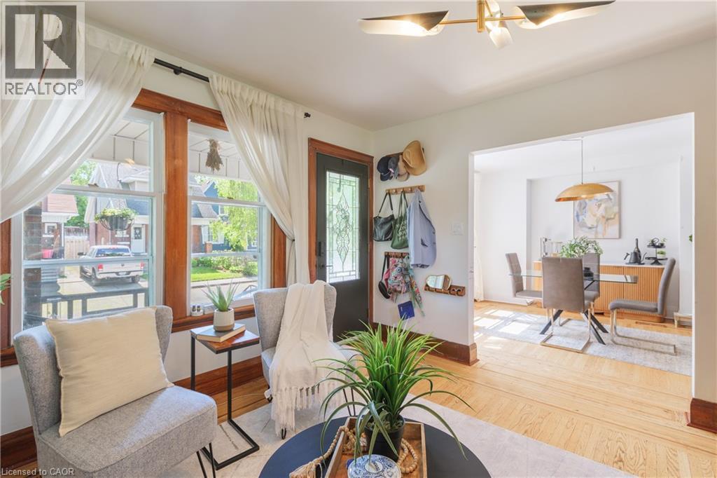 Living room featuring abundant natural light, hardwood flooring, and a decorative ceiling fixture - 41 Park Row N, Hamilton, ON