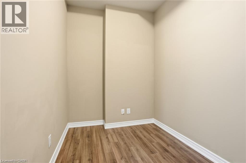 Compact room featuring wood-finish flooring and neutral-toned walls - 40 Esplanade Lane Unit# 614, Grimsby, ON