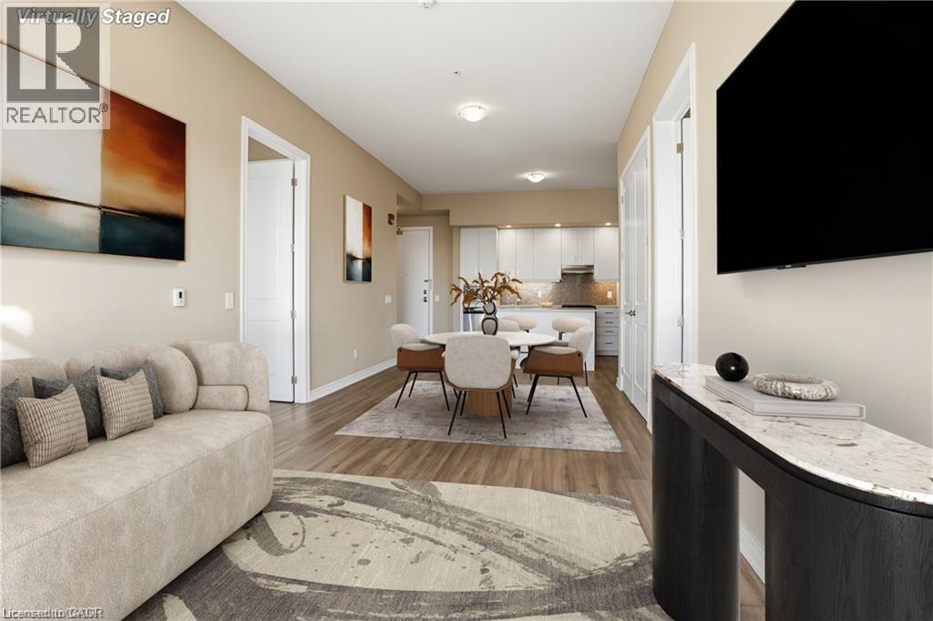 Open-concept living space featuring wood-finish flooring, recessed lighting, and a neutral color palette - 40 Esplanade Lane Unit# 614, Grimsby, ON