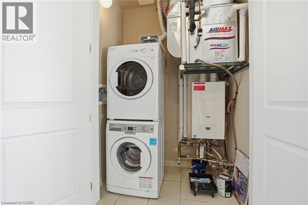 Dedicated utility closet with a stackable washer and dryer, tankless water heater, and forced air unit - 40 Esplanade Lane Unit# 614, Grimsby, ON