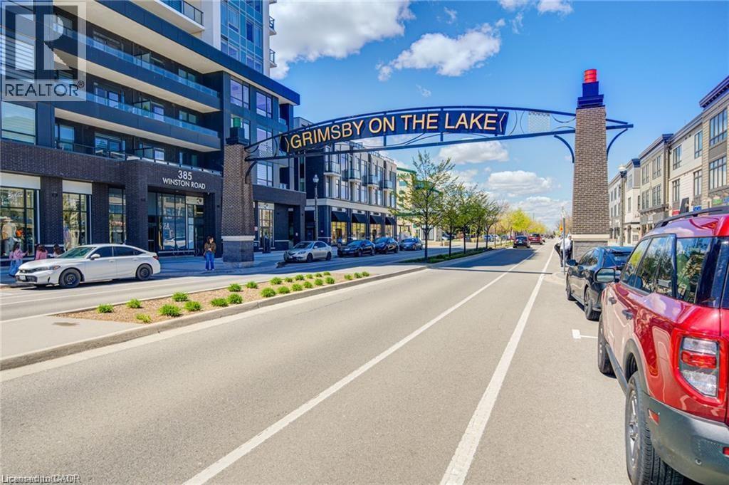 Modern high-rise residential building with dark brick and glass facade - 40 Esplanade Lane Unit# 614, Grimsby, ON