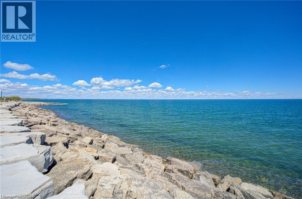 Expansive body of water with a clear horizon and rocky shoreline - 40 Esplanade Lane Unit# 614, Grimsby, ON
