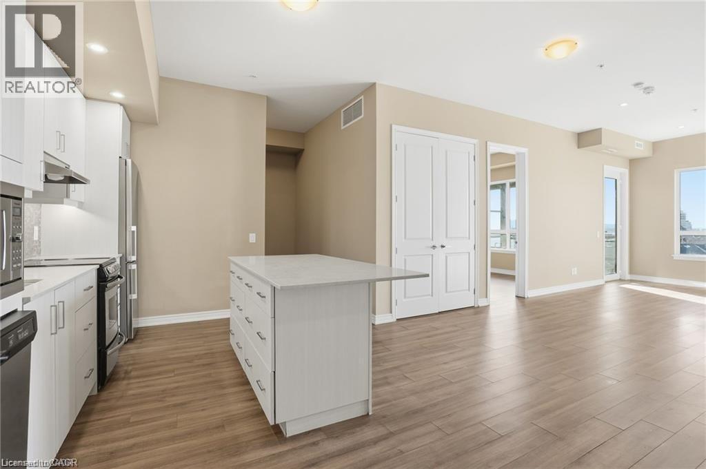 Open-concept living space with wood-finish flooring - 40 Esplanade Lane Unit# 614, Grimsby, ON