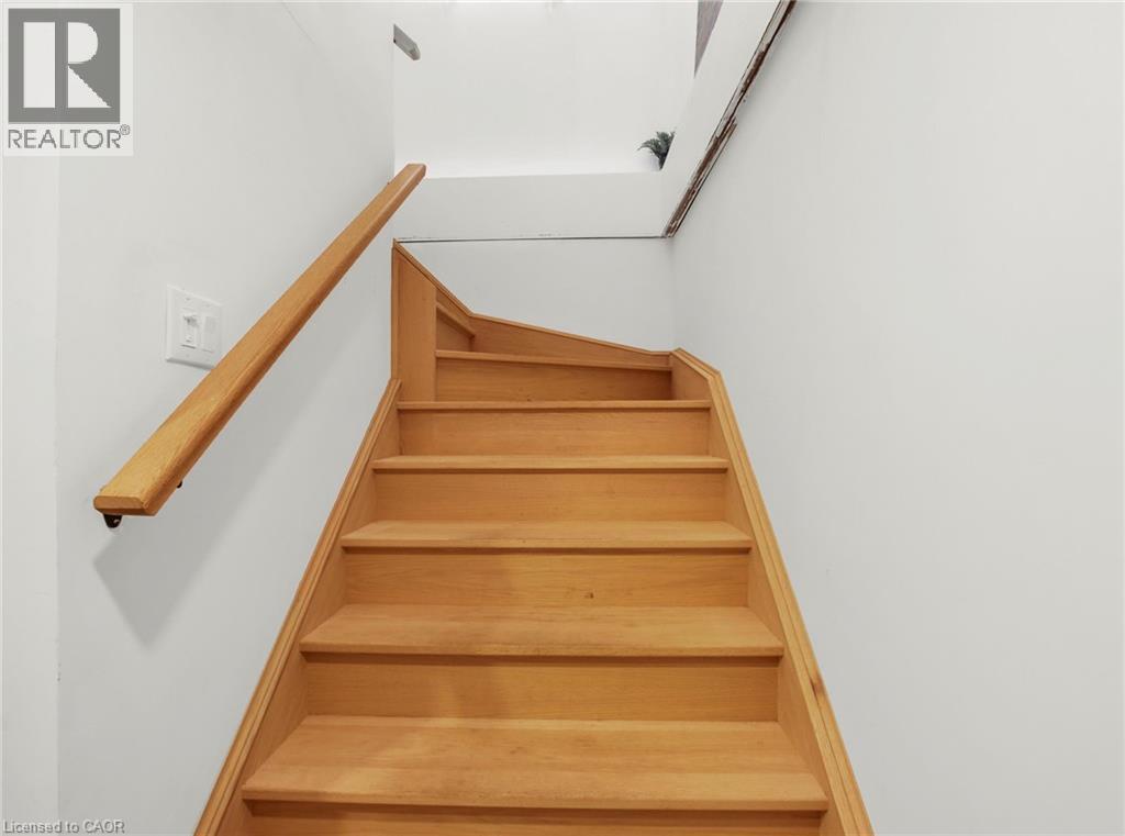 Staircase with wood-finish treads and risers, complemented by a solid wood handrail - 420 Waverly Street, Hamilton, ON