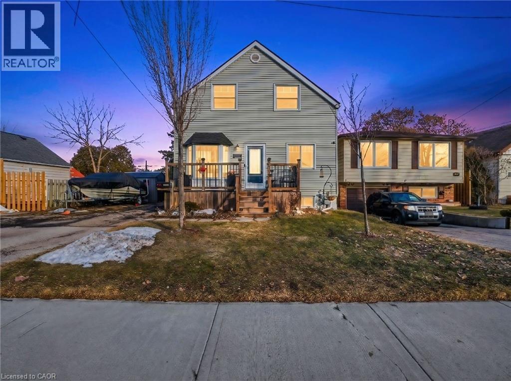 Light-colored siding exterior with a prominent bay window and an elevated front porch - 420 Waverly Street, Hamilton, ON