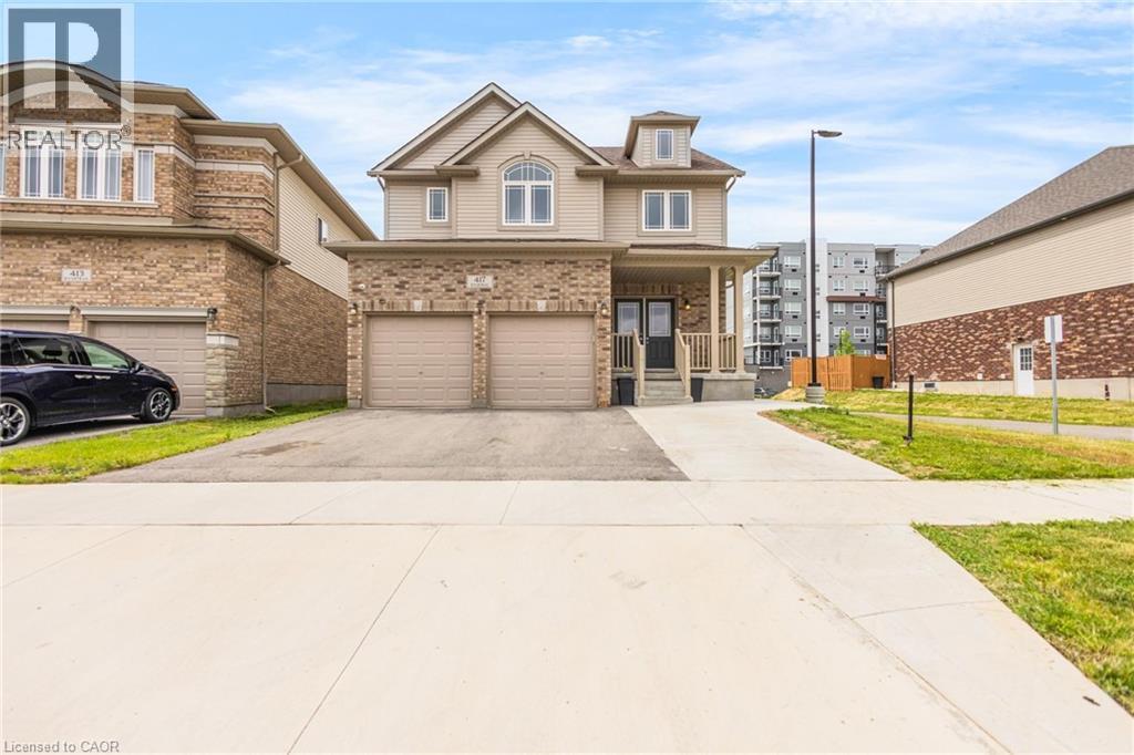 Two-story residence featuring a brick and siding exterior, a covered front porch, and a two-car garage with individual doors - 417 Rivertrail Avenue, Kitchener, ON