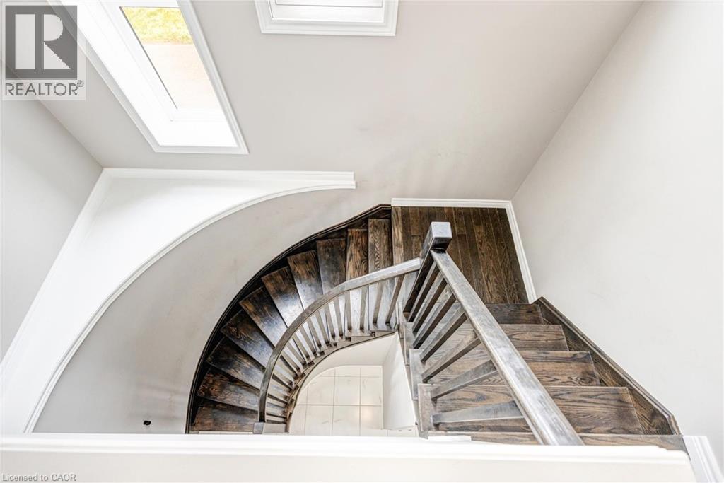 Architectural staircase featuring dark wood treads and a coordinating banister - 417 Rivertrail Avenue, Kitchener, ON