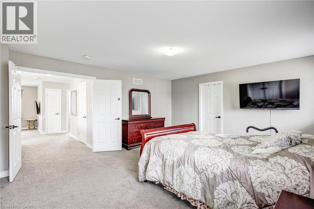 Carpeted bedroom with neutral wall tones and a ceiling-mounted light fixture - 417 Rivertrail Avenue, Kitchener, ON