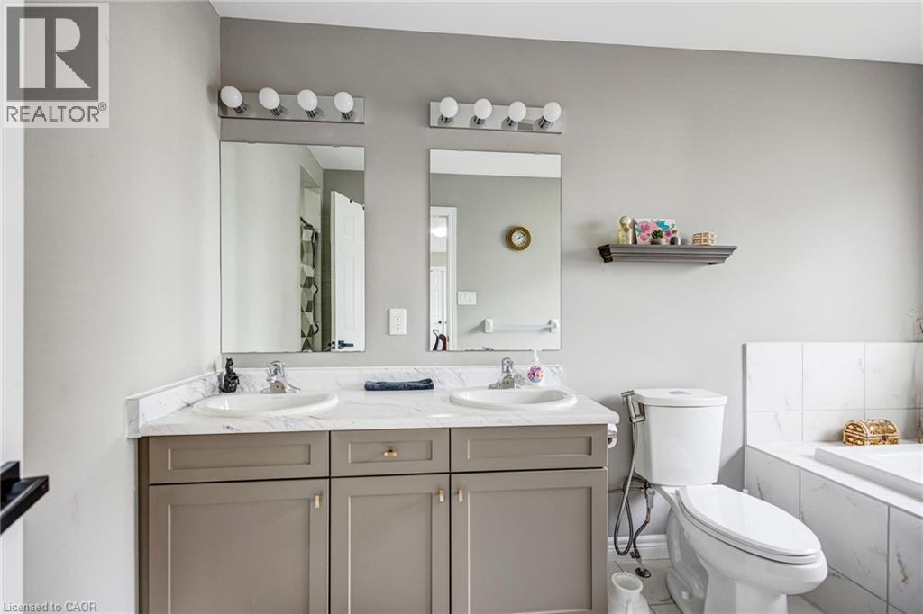 Dual vanity with white countertop, undermount sinks, and light gray cabinetry - 417 Rivertrail Avenue, Kitchener, ON