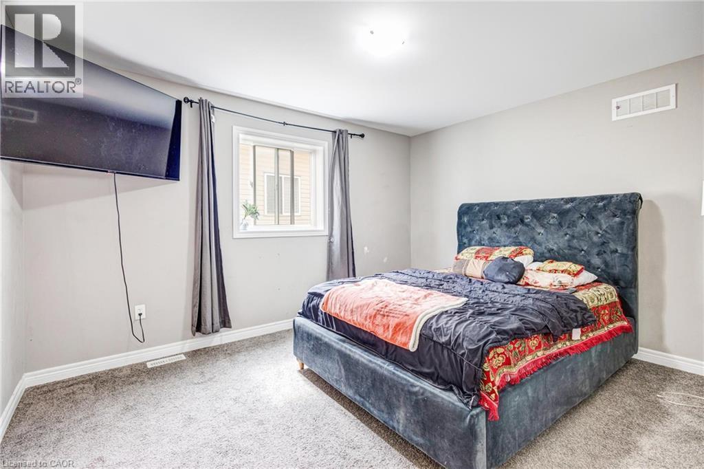 Neutral-toned wall paint with white trim, a single window with dark draperies, and a neutral carpeted floor - 417 Rivertrail Avenue, Kitchener, ON