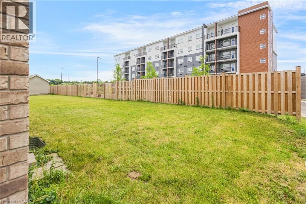Expansive green lawn outlined by a light wood privacy fence - 417 Rivertrail Avenue, Kitchener, ON