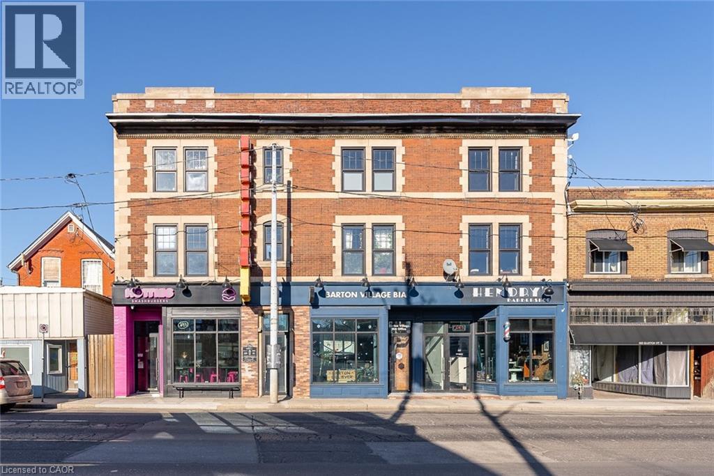 Brick facade building featuring multiple storefronts and upper-level windows - 657 Barton Street E Unit# 302, Hamilton, ON