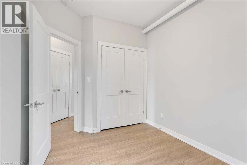 Room featuring wood-finish flooring, light grey walls, and white trim - 657 Barton Street E Unit# 302, Hamilton, ON