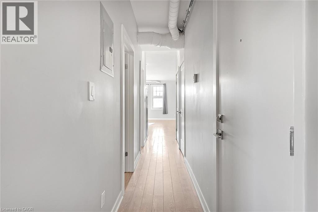 Hardwood-finish flooring extending through the hallway - 657 Barton Street E Unit# 302, Hamilton, ON