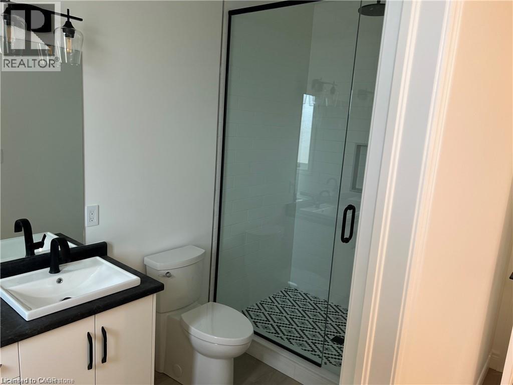 Full bath featuring vanity, a stall shower, and toilet - 207 Arden Crescent Unit# Upper Level, Mitchell, ON