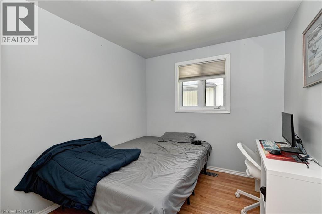Room featuring light gray walls, wood-finish flooring, and a single window with white trim - 525 Fallingbrook Drive, Waterloo, ON