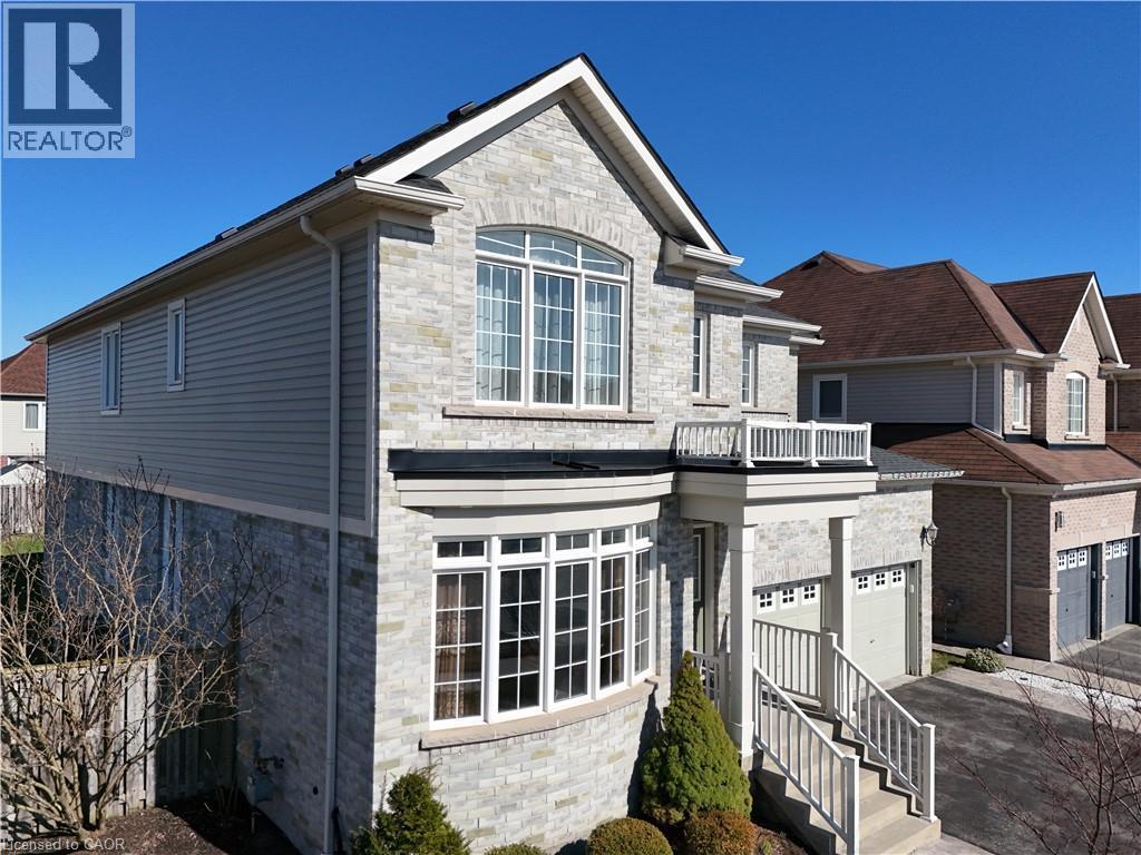 View of front facade featuring stone siding, an attached garage, a balcony, and asphalt driveway - 512 Terrington Crescent, Kitchener, ON