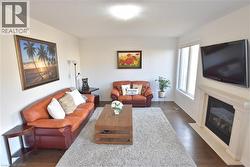 Living room featuring dark wood finished floors and a fireplace with flush hearth -