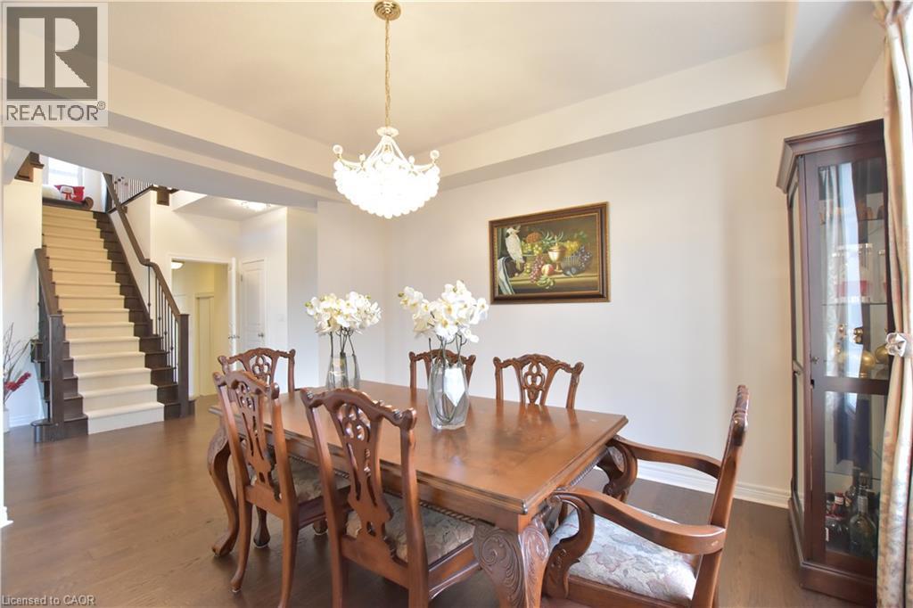 Dining area with a tray ceiling, suspended lighting, and dark wood-style flooring - 512 Terrington Crescent, Kitchener, ON