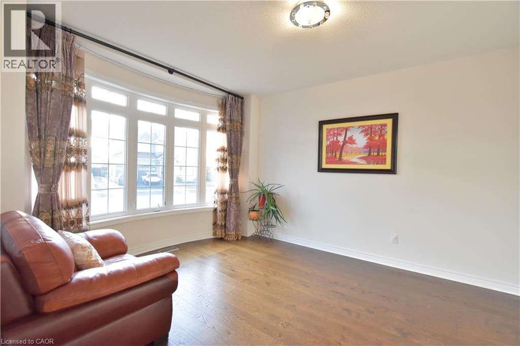 Sitting room with wood finished floors and baseboards - 512 Terrington Crescent, Kitchener, ON