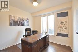 Office with dark wood-style flooring and baseboards -