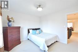 Bedroom featuring light colored carpet and baseboards -