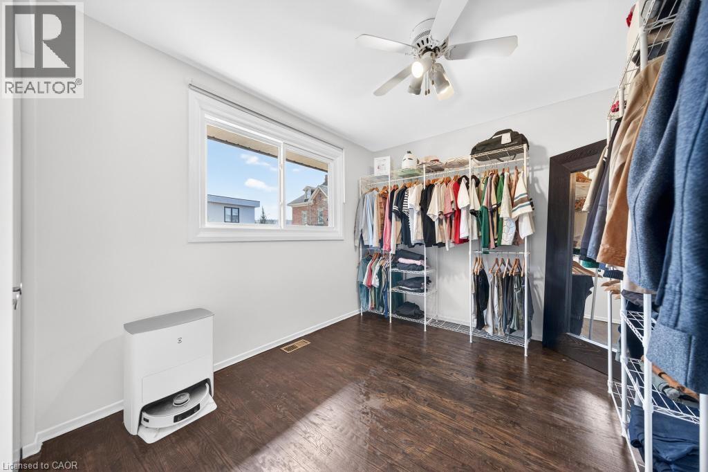Room with wood-finish flooring, a white ceiling fan with integrated lighting, and a large window - 19 Glen Forest Drive, Hamilton, ON