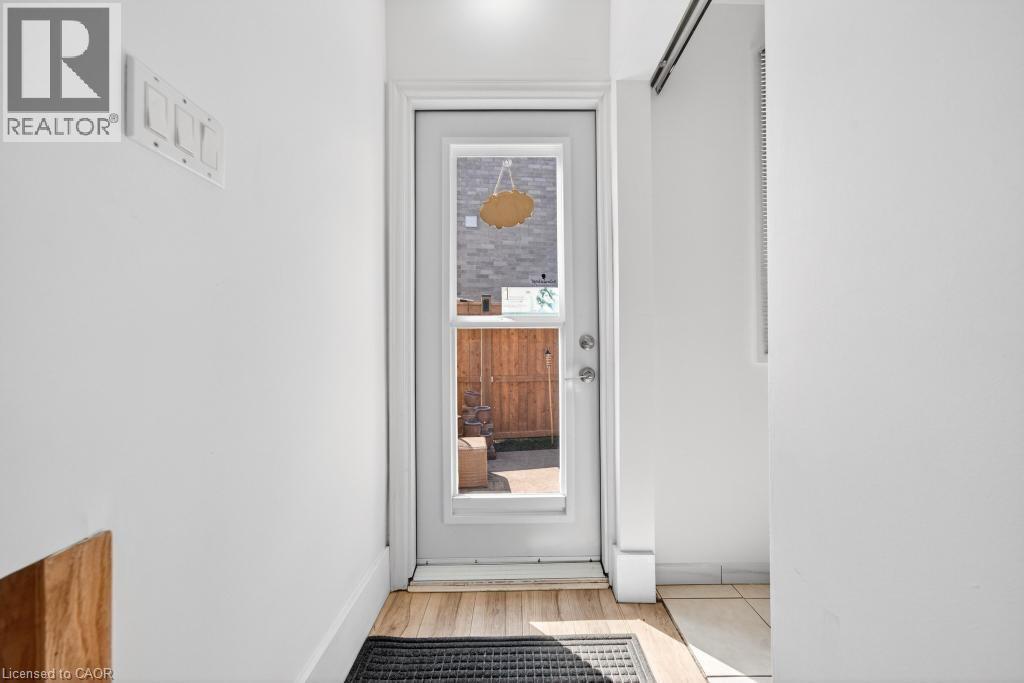Entryway with a glass-paned door, wood-finish flooring, and white baseboards - 19 Glen Forest Drive, Hamilton, ON