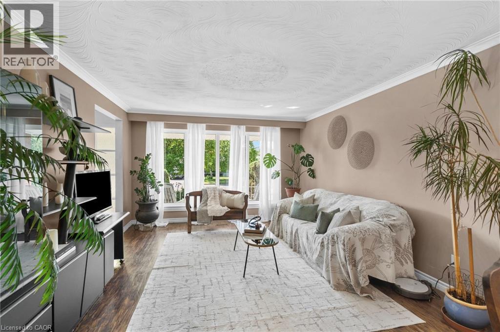 Living area featuring wood-finish flooring, light-toned walls, and white crown molding - 1083 Melton Drive, Mississauga, ON
