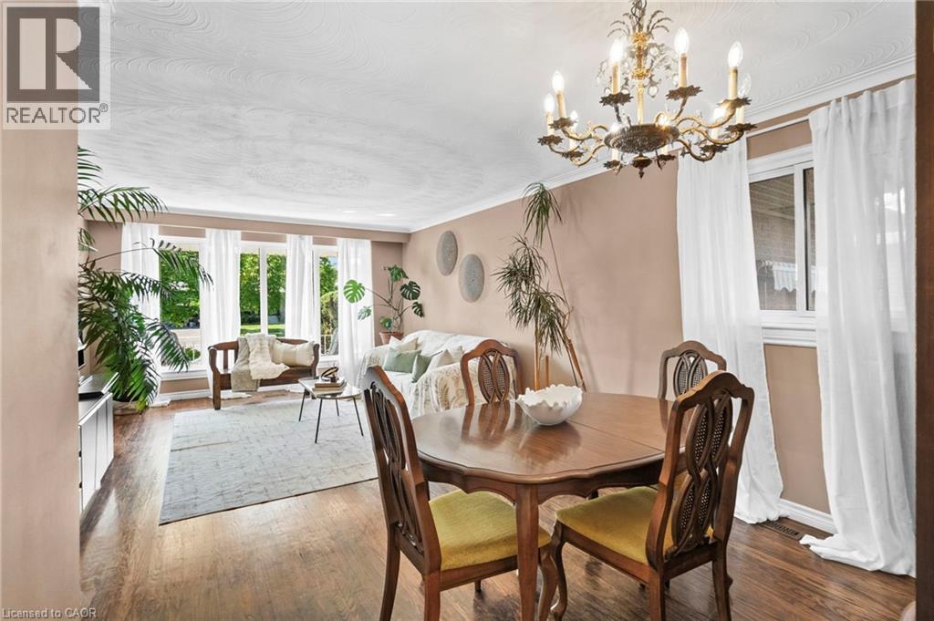 Dining area featuring a classic chandelier and wood-finish flooring - 1083 Melton Drive, Mississauga, ON