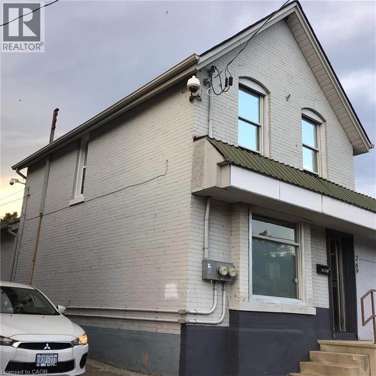 Two-story brick exterior with a gabled roofline and arched upper windows - 269 Cannon Street E, Hamilton, ON