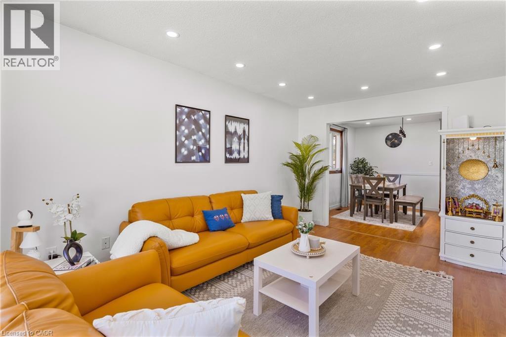 Open-concept living area featuring recessed lighting, light wood-finish flooring, and a defined dining space beyond - 102 Juniper Drive, Hamilton, ON